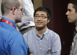 Panelist and UNMC researcher Bin Duan, Ph.D., meets with guests immediately after the event.