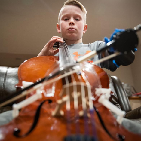 Brendan Sullivan/Omaha World-Herald Lincoln fourth-grader Peyton Tiernan can now play the cello with a prosthesis design by a UNO team — am arm with a clamp on the end that locks onto the bow. Read the full article at: https://www.omaha.com/livewellnebraska/inspiration/lincoln-boy-learns-cello-with-help-from-a-uno-designed/article_5baf4226-d347-5e6e-a95b-ae1273b6a3a3.html